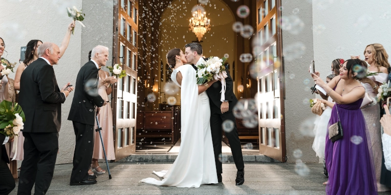 Una pareja besándose al salir de la iglesia.